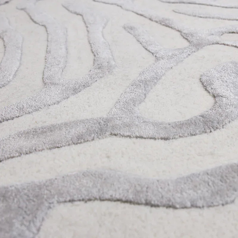 Close-up of textured cream and grey rug with abstract raised line pattern
