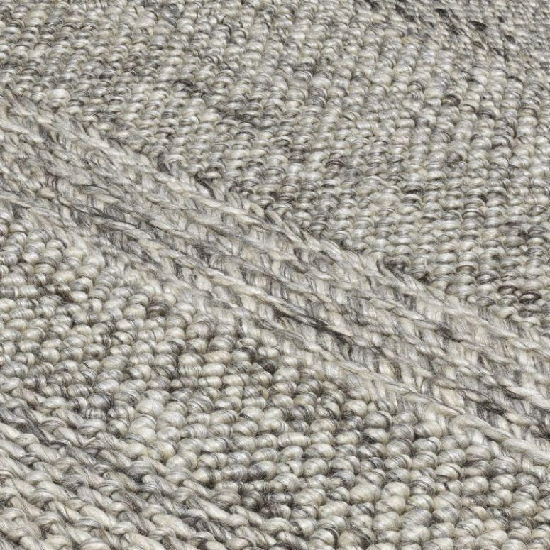 Close view of textured woven rug in grey tones showing looped wool detail