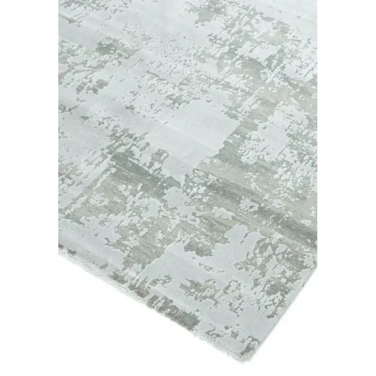 Modern area rug with abstract grey and white pattern, close-up corner angle