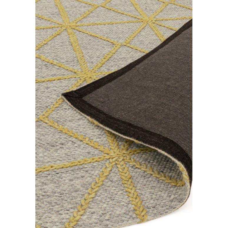 Grey and yellow woven rug with geometric pattern, close-up showing corner and texture