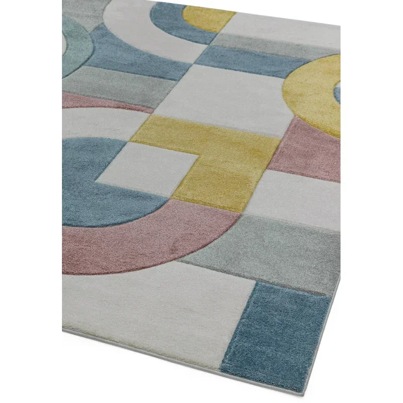 Geometric patterned rug with pastel blue, yellow, pink, and grey shapes
