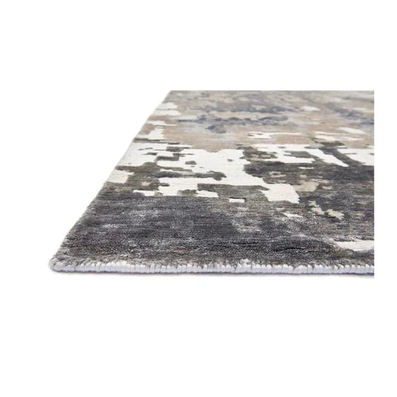 Close-up of abstract area rug with grey, beige, and white pattern on flat surface