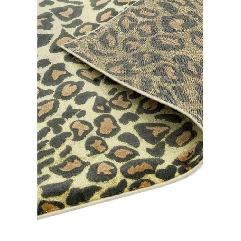 Leopard print area rug with beige, brown, and black pattern and folded corner detail