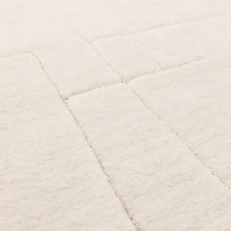 Close view of cream textured rug with subtle geometric pattern