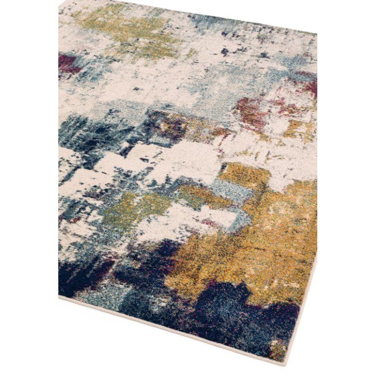 Abstract area rug with blue, yellow, and cream tones, close-up corner view
