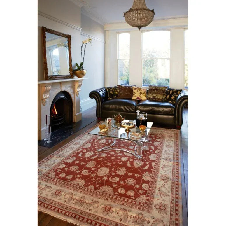 Red patterned area rug with cream border in traditional living room setting