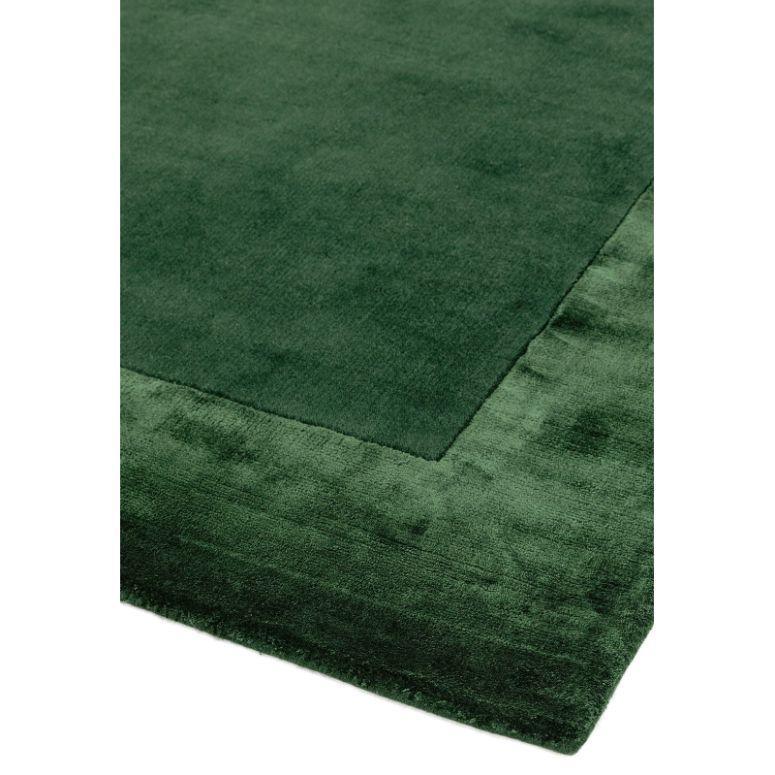 Dark green bordered rug with soft pile and rectangular corner detail
