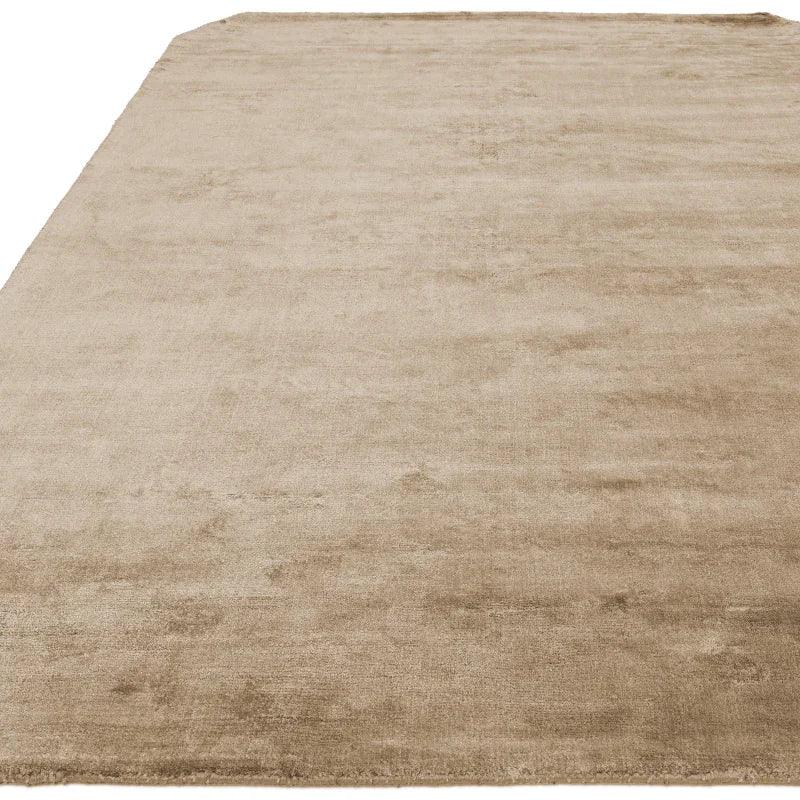 Beige area rug with soft texture and plain design shown from angled view