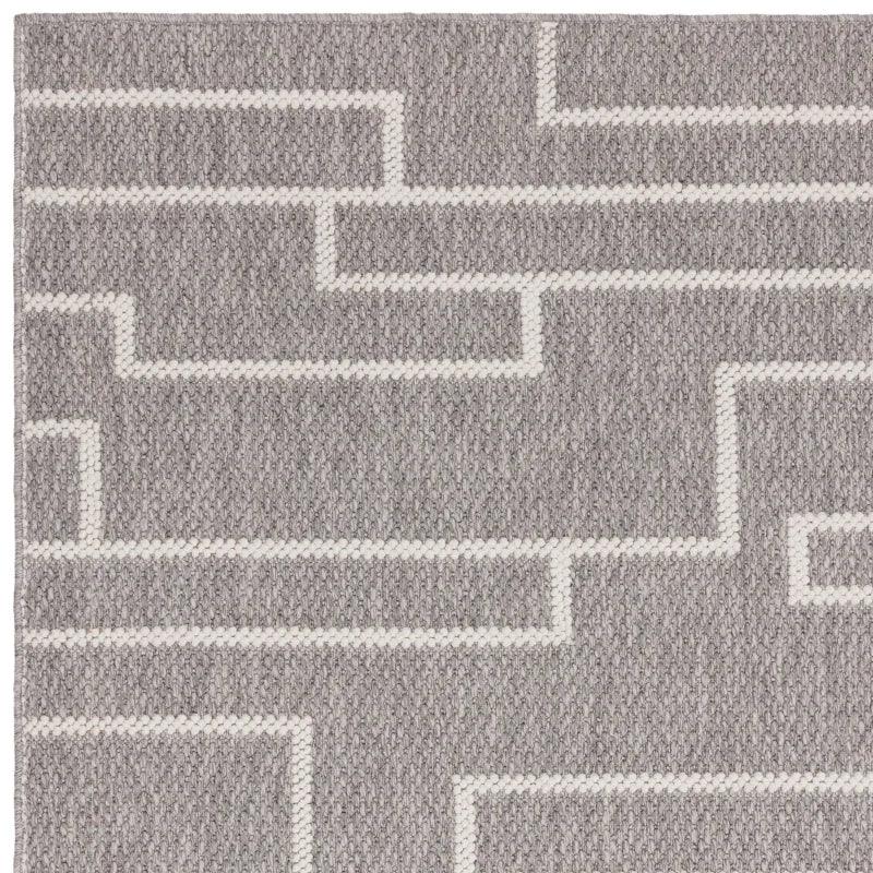 Grey wool rug with white geometric pattern, close-up of textured surface