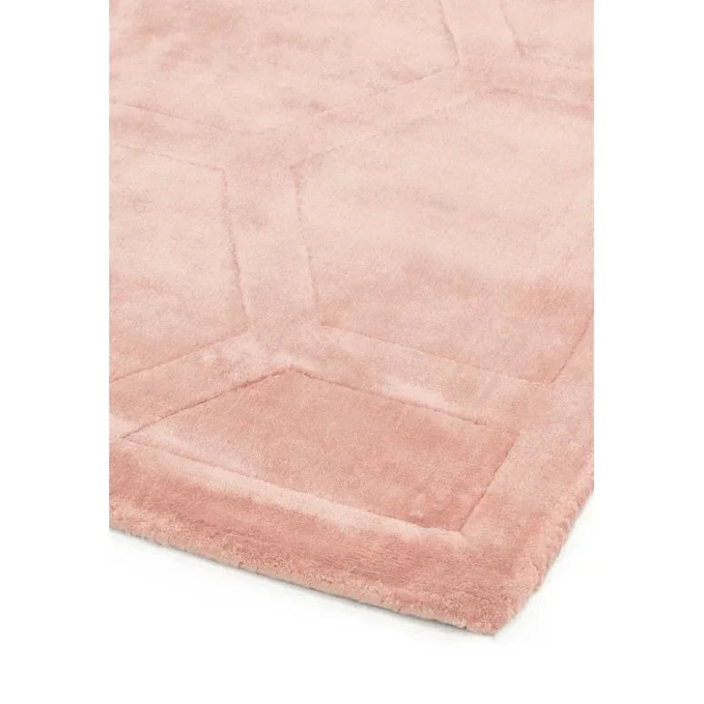 Blush pink geometric area rug with soft pile and subtle textured pattern, corner detail view