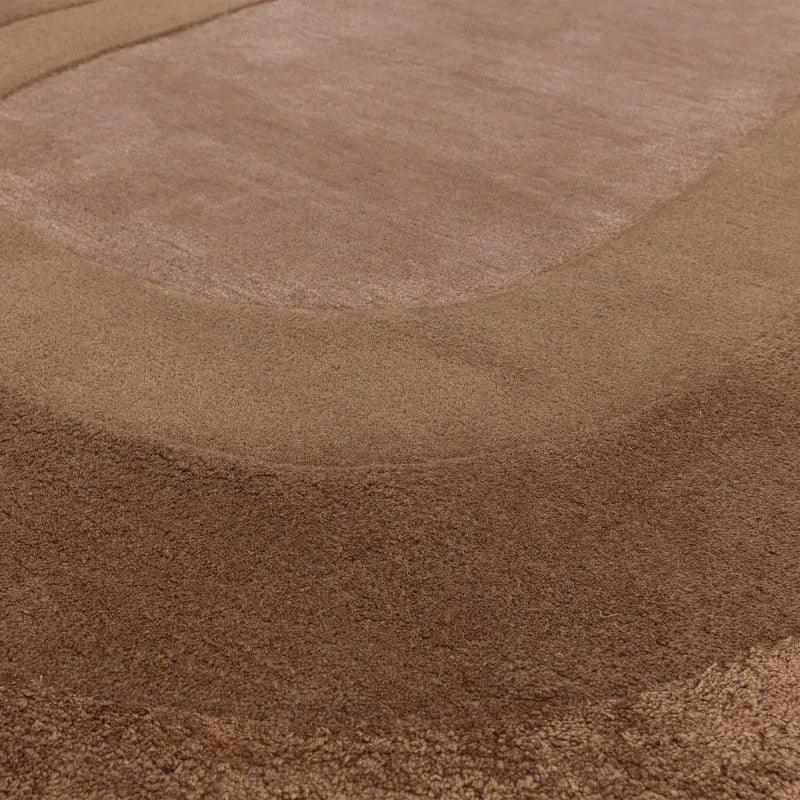 Close-up of brown area rug with textured, raised border design