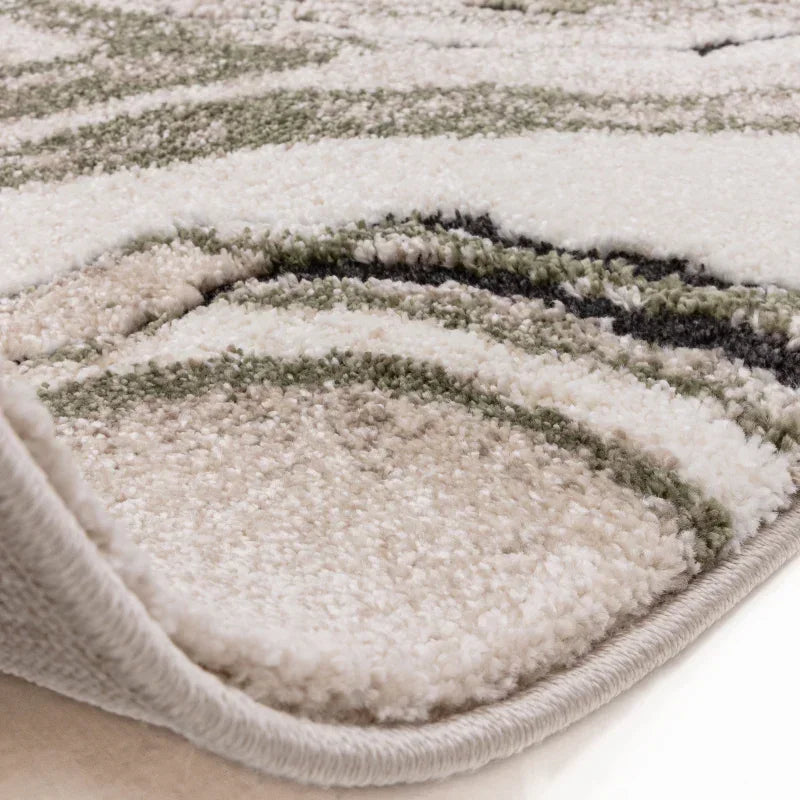 Close-up of modern area rug with beige, cream, and green textured pattern
