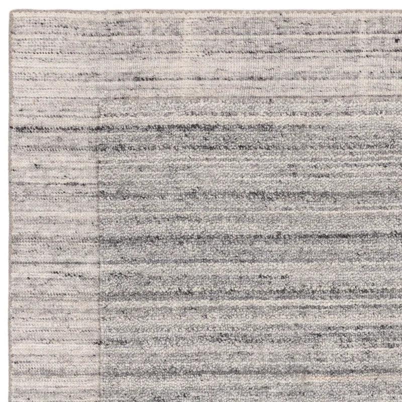Grey textured area rug with subtle horizontal stripes and simple border detail