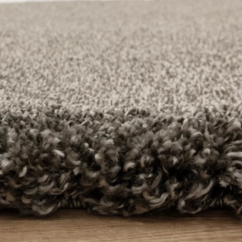 Close-up of grey shaggy rug texture on wooden floor