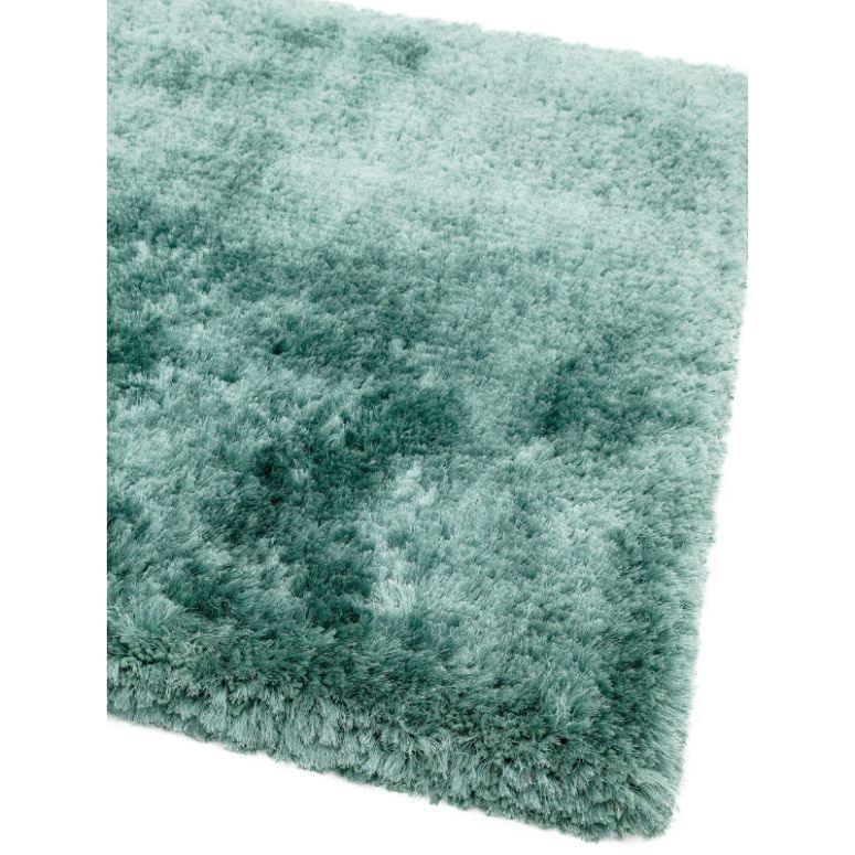 Soft teal shaggy rug corner with thick pile texture