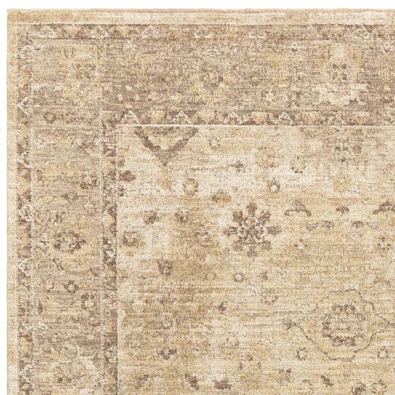 Beige patterned area rug corner with traditional floral motifs and textured weave