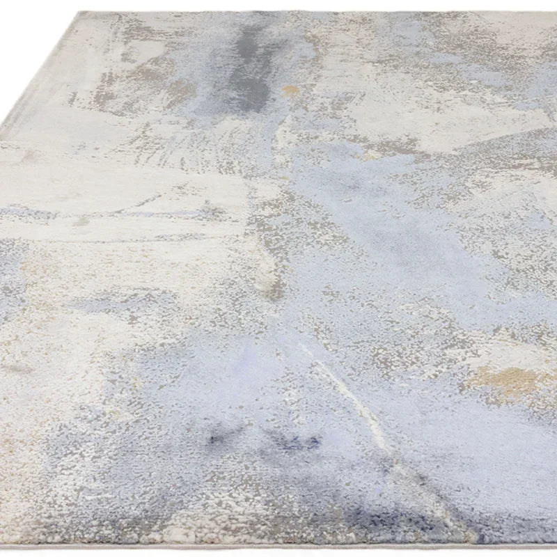 Modern area rug with abstract blue, grey, and cream pattern and soft textured surface