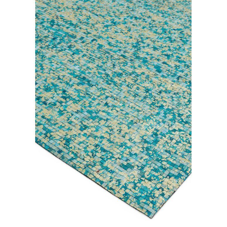 Blue and beige patterned area rug with geometric mosaic design, corner view
