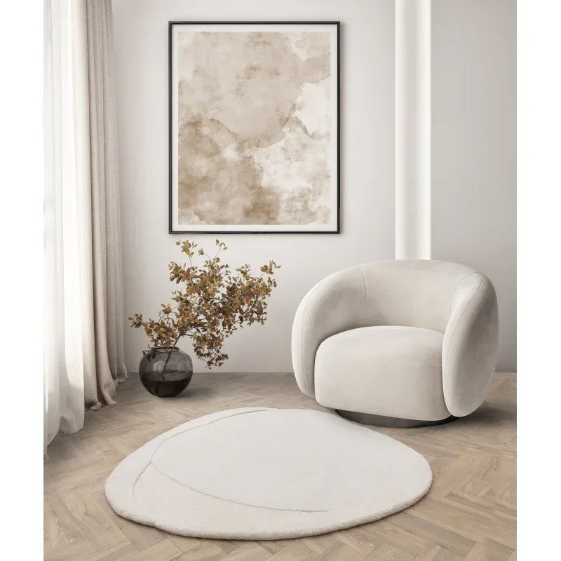 Cream swivel armchair with soft upholstery beside round beige rug in modern living room