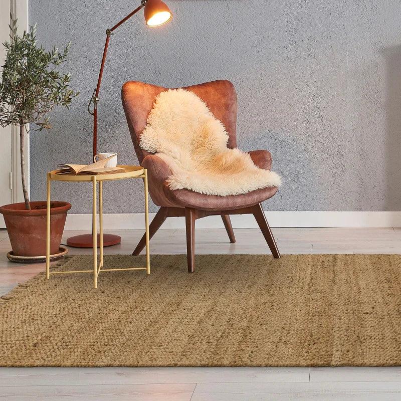 Natural jute rug in living room with brown accent chair, side table and floor lamp