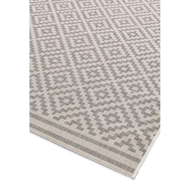 Grey geometric patterned rug corner with woven texture