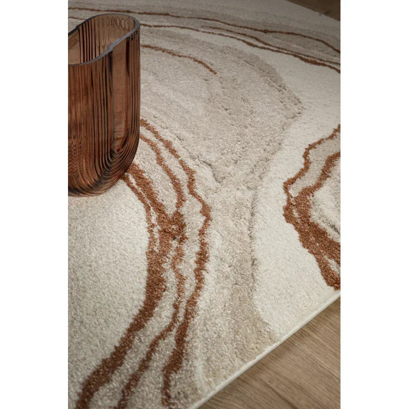 Beige and brown abstract area rug on wooden floor with modern brown glass vase