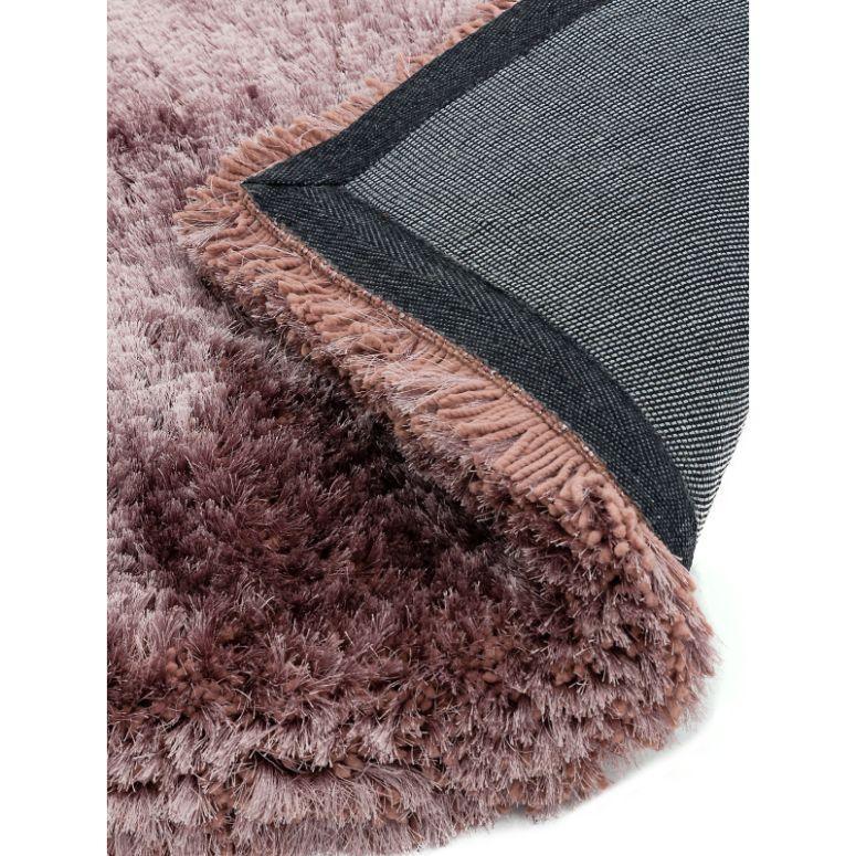 Closeup of soft pink shaggy rug with grey fabric backing