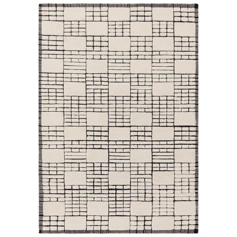 cream and black patterned rug with geometric squares and border detail, flat lay view