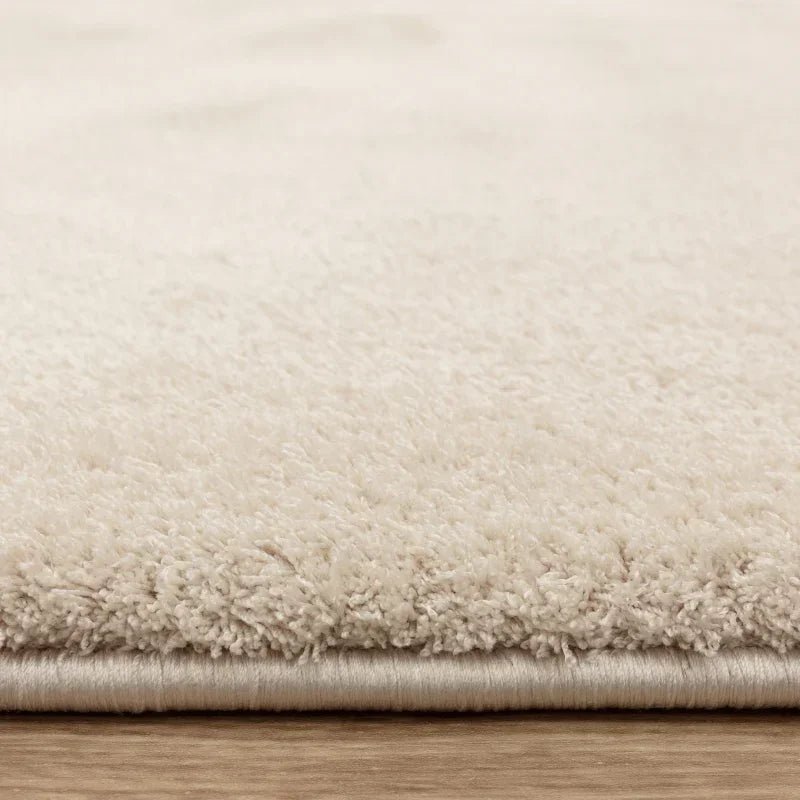 Close-up of cream shaggy rug on wooden floor
