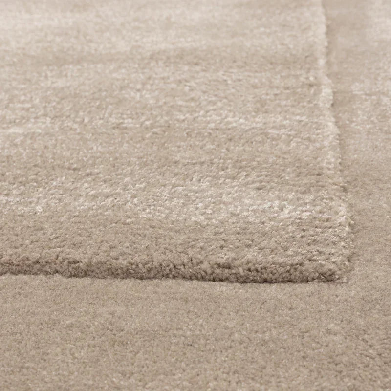 Close up of beige rug with soft plush pile and textured border detail
