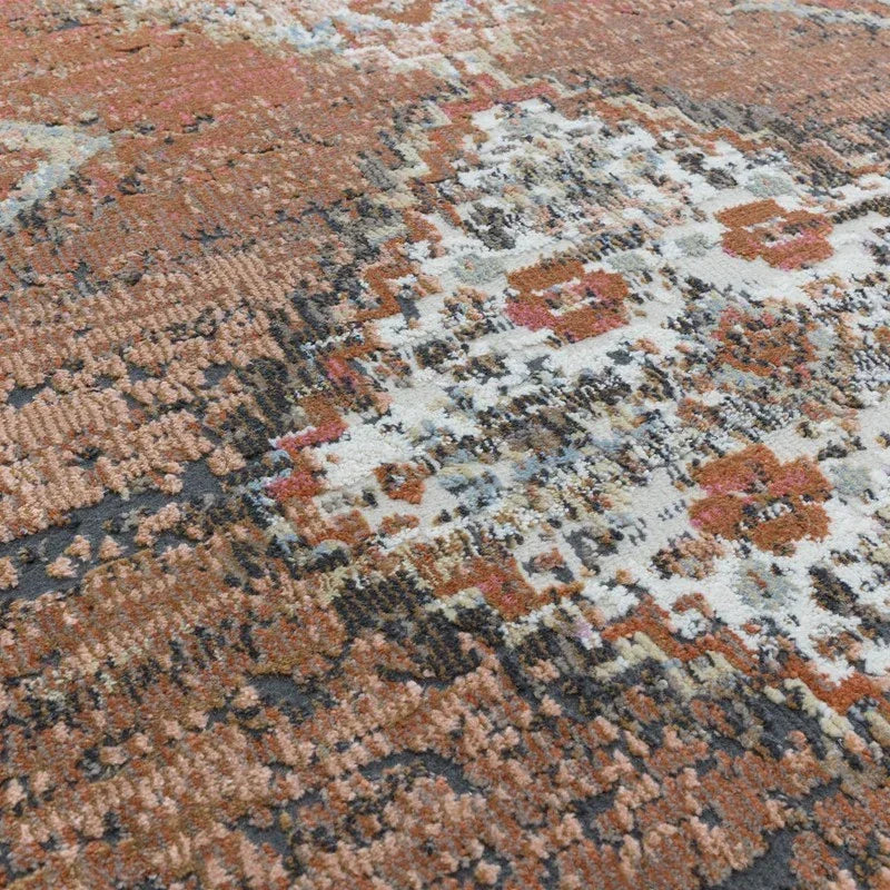 Close-up of patterned rug with terracotta, cream, and grey textured fibers
