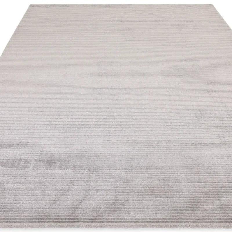 Light grey area rug with subtle linear texture, shown from low angle
