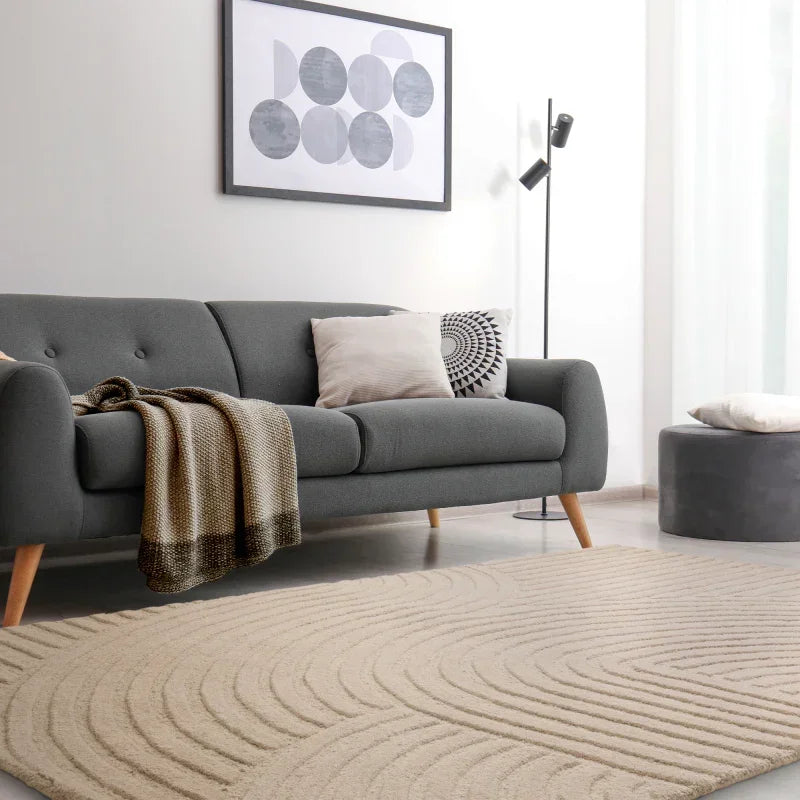 Grey fabric sofa with wooden legs, neutral cushions, and throw in modern living room setting