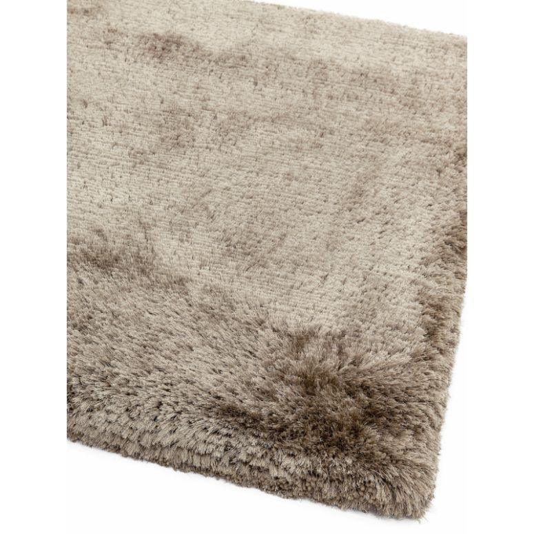 Beige shaggy rug with thick pile and textured corner detail