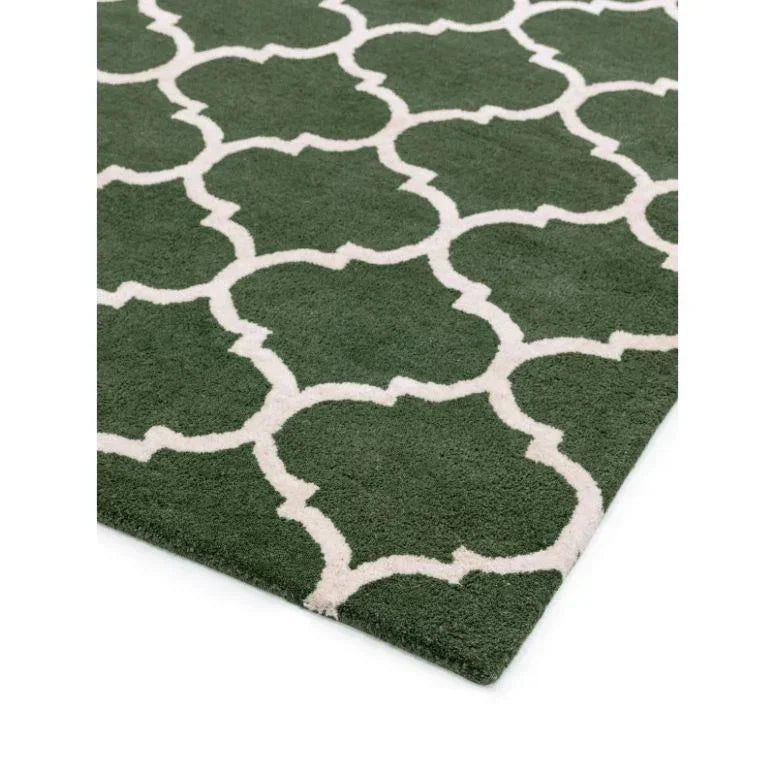 Green area rug with white geometric trellis pattern, closeup corner view