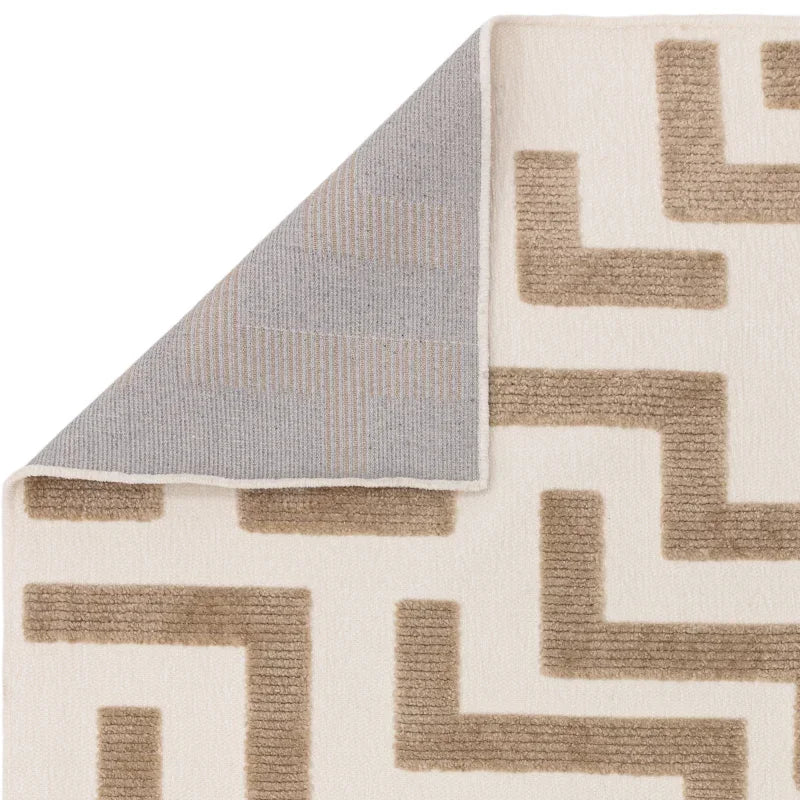beige geometric pattern rug with cream background and gray underside corner detail