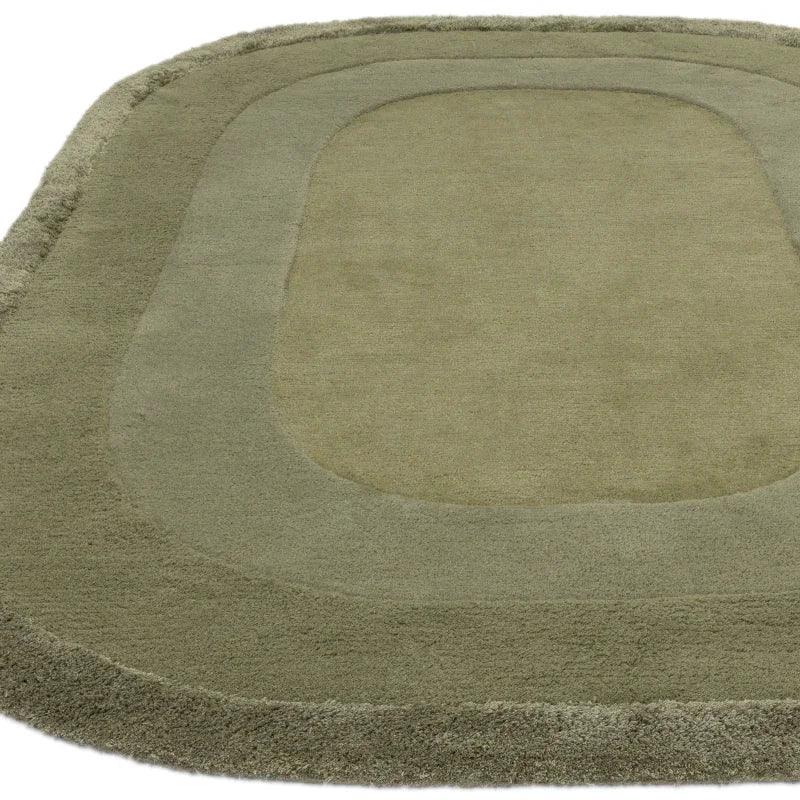Olive green wool rug with geometric border pattern and plush texture, angled view