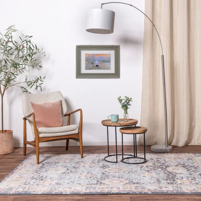 Living room with accent chair, wooden nesting tables, floor lamp, large area rug