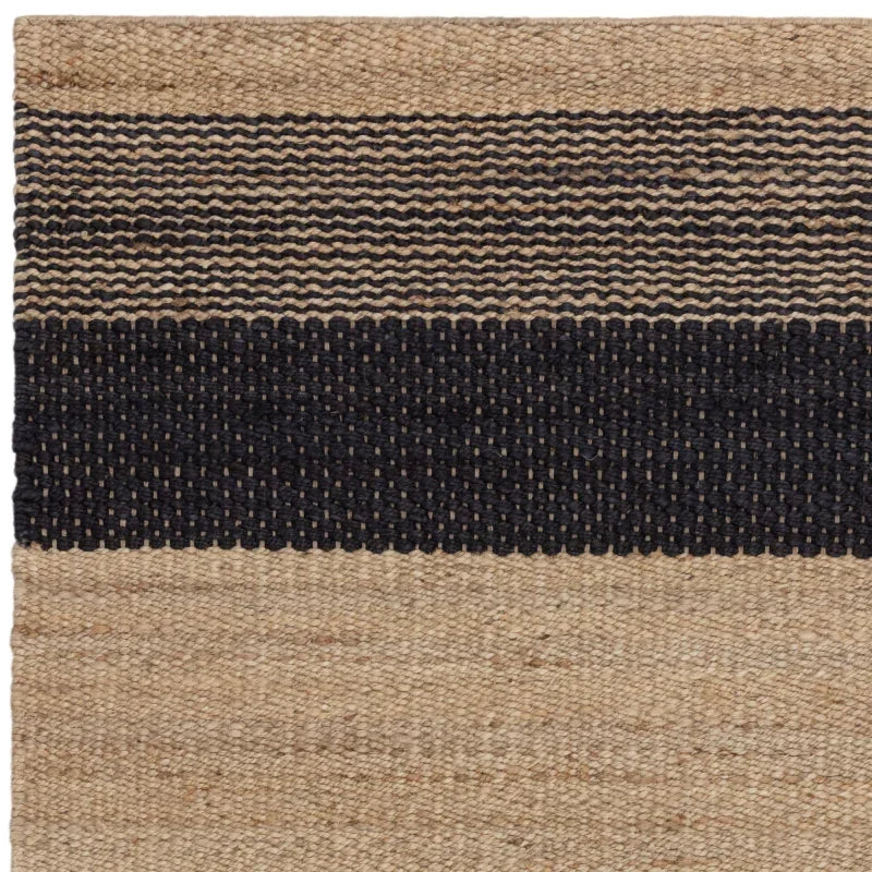 natural jute rug with black woven stripe and textured pattern, corner close-up view