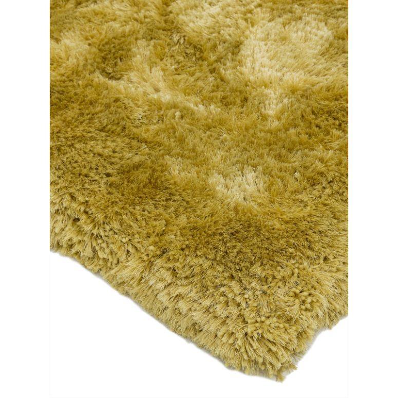 Close up of yellow shaggy rug with soft thick pile and textured surface