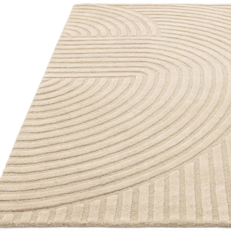 Beige textured rug with raised curved geometric pattern, shown from a side angle