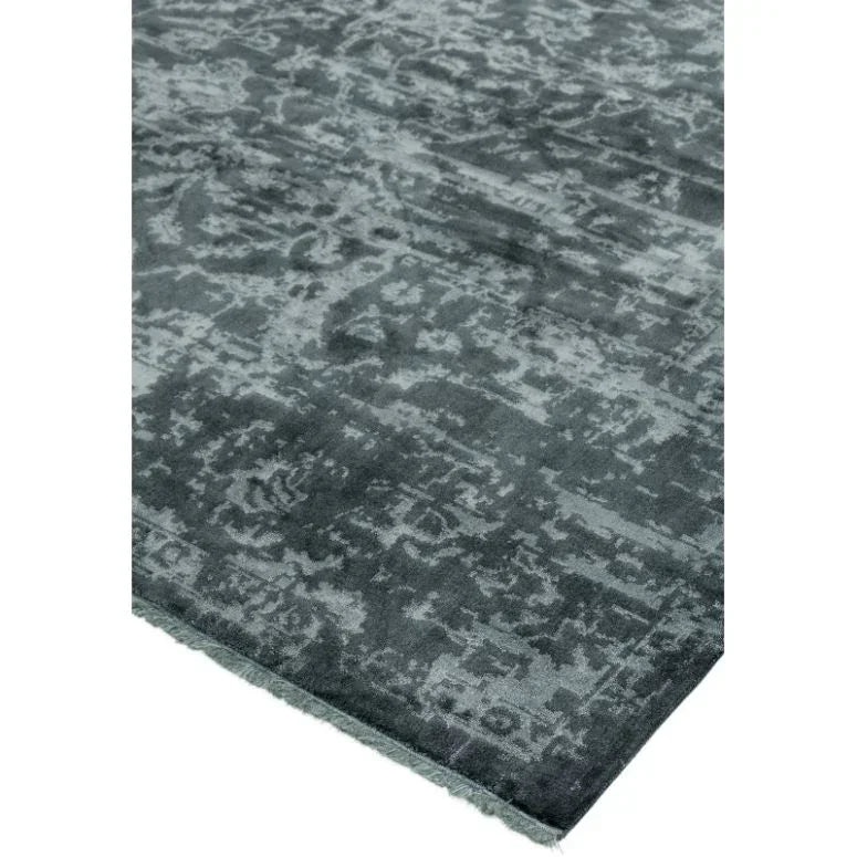 Grey patterned area rug with distressed finish, close-up of corner and texture
