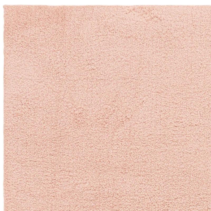 Blush pink shaggy rug with soft textured surface, close-up view of pile material