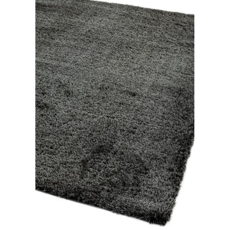 Dark grey shaggy rug with soft pile and rectangular shape, close corner view