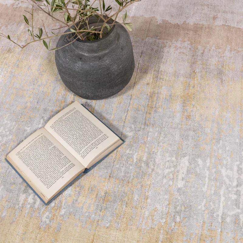 Neutral abstract area rug with open book and decorative grey vase on top