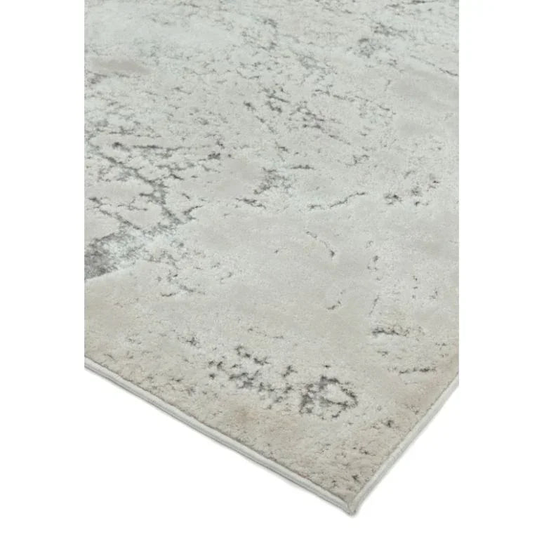 Light grey area rug with subtle abstract pattern and short pile, corner view