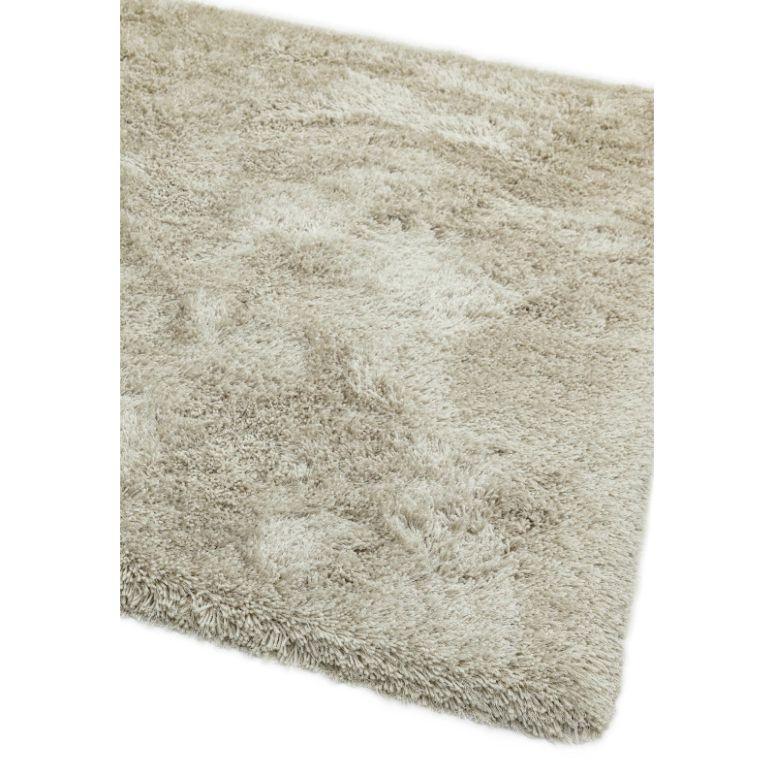 Beige shaggy rug with thick pile and soft texture, close corner detail