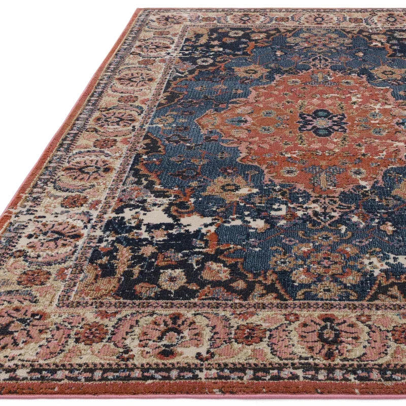 Traditional patterned area rug with red, navy and beige tones, detailed floral border