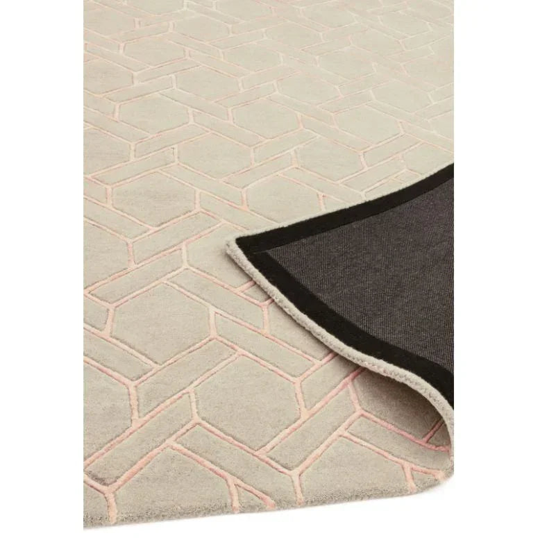Beige geometric patterned rug with corner flipped showing non-slip backing