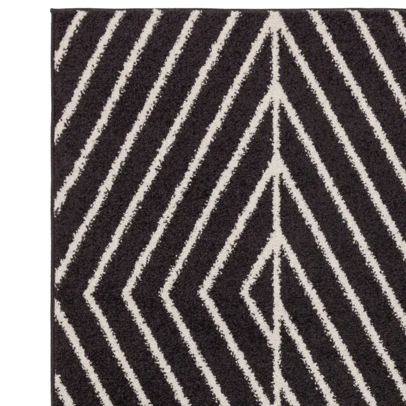 Black and cream geometric rug with chevron stripe pattern, corner angled view